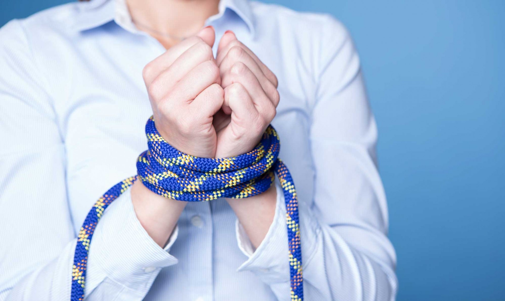 persona con las manos atadas con cuerda azul
