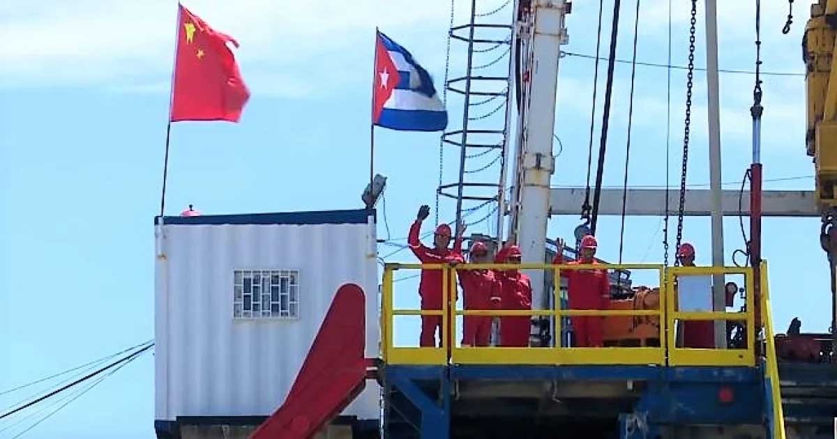 banderas chinas y cubanas en un barco con hombres vestido de naranja