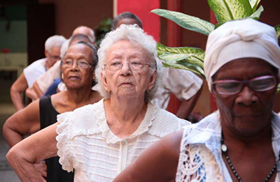 Older cuban women in line with their hands on hips, with the center figure dressed in white