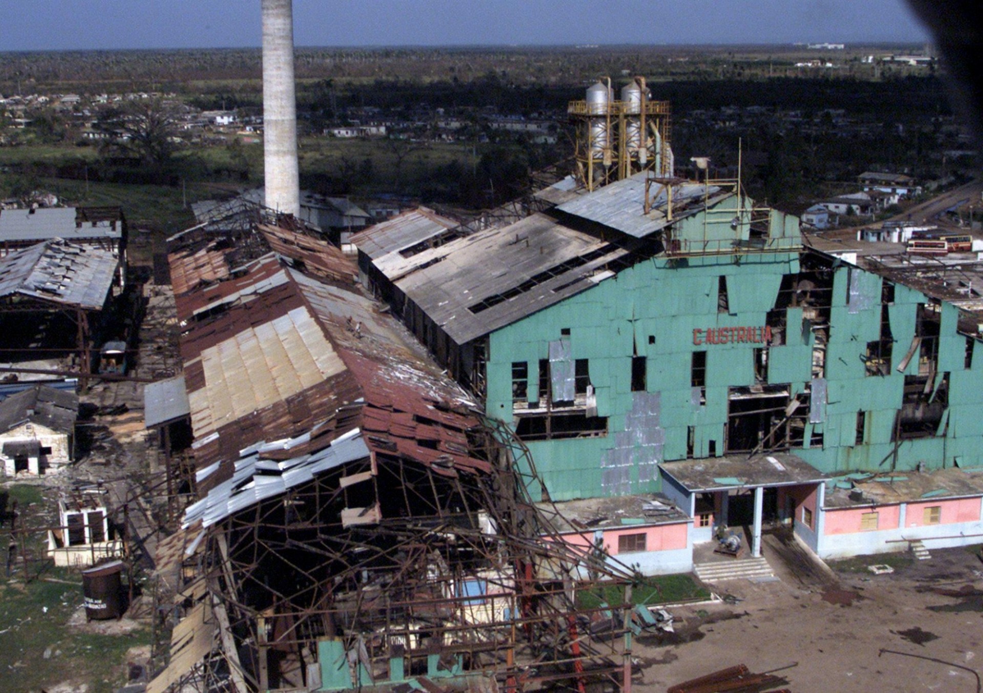 Sugar mil with tower and green building with holes in the structure