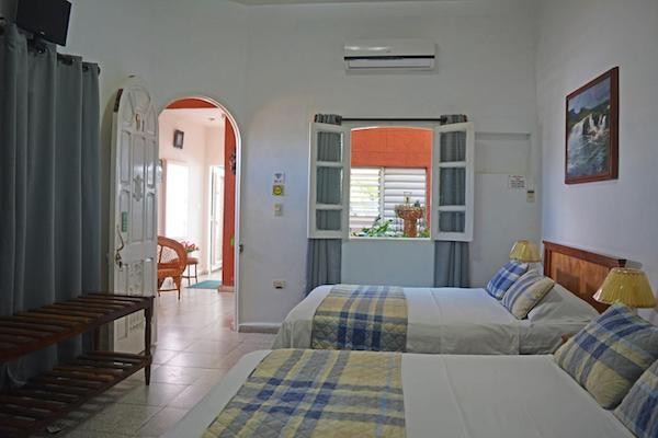 BR& Hostal Cienfuegos Center Cuarto de hospedaje con dos camas y ventanas abiertas a un salón