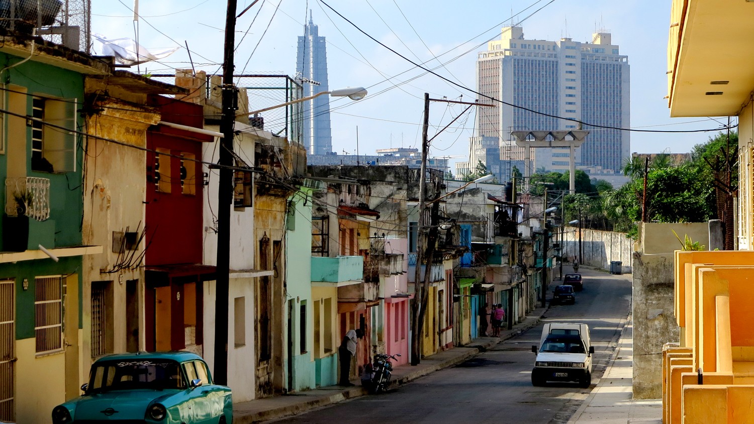 Calle con casas multicolores medias retorcidas y cables de electricidad colgando adelante