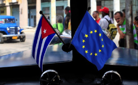 Flags of Cuba and the EU in the windshield of a car in Havana