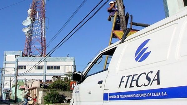 camioneta con letras ETECSA al lado de líneas de teléfono con torre electrónica y cielo azul