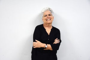 Ileana Díaz Fernández mujer sonriente vestida de negro con brazos cruzados contra fondo blanco