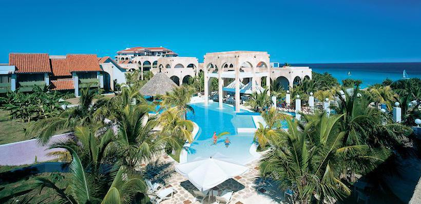 Meliá Las Américas, Varadero, Cuba hotel complex of white buildings with pool in center, blue sky and caribbean sea in background