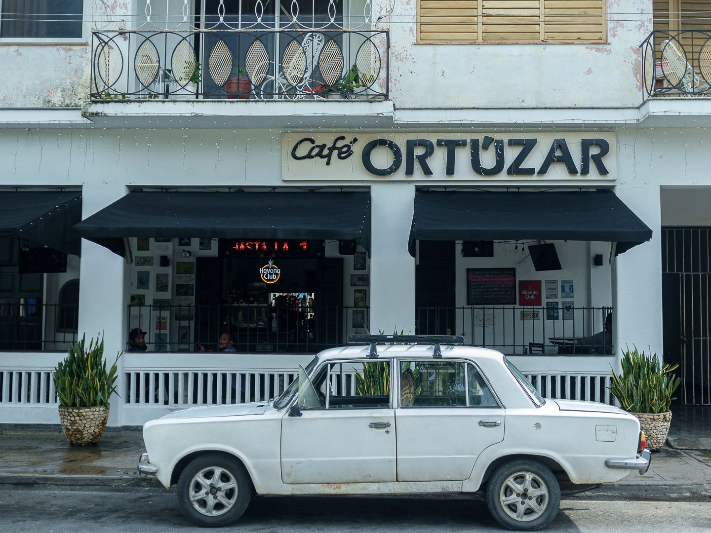 auto blanco en frente de un café en Pinar del Rio