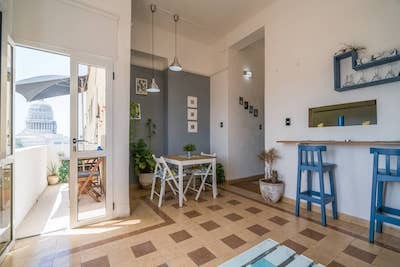 interior of an apartment with grey colors, a balcony and a view of the Cuban capital building in the background