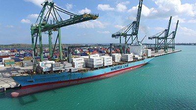 Barco de transporte comercial, grúas de envio, mar aquamarino con fondo de cielo azul 