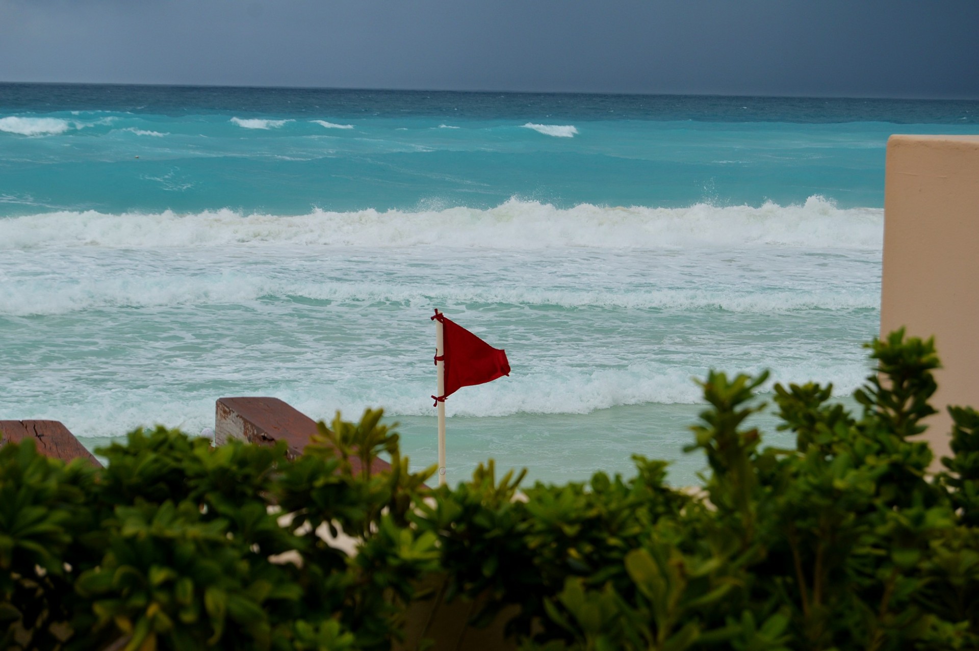 Bandera roja en una playa de agua azul anunciando aguas peligrosas