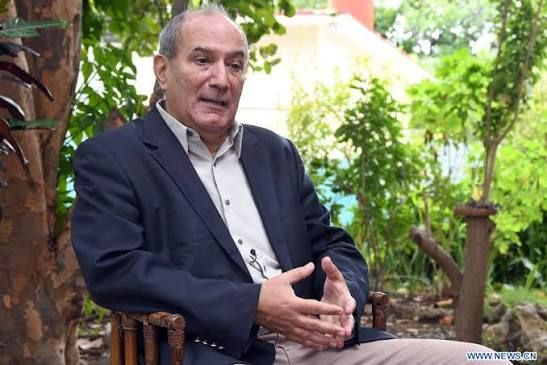 En la imagen aparece el Dr. Antonio Romero Gómez, sentado frente a un espacio adornado con diversas plantas.