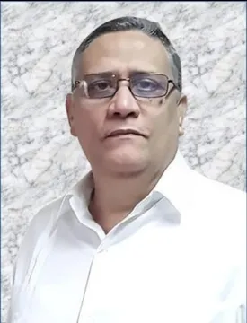 Retrato de primer plano de un hombre de mediana edad con gafas de montura oscura. Viste una camisa blanca formal y mira directamente a la cámara con una expresión serena. El fondo tiene una textura que simula mármol en tonos claros y grises.