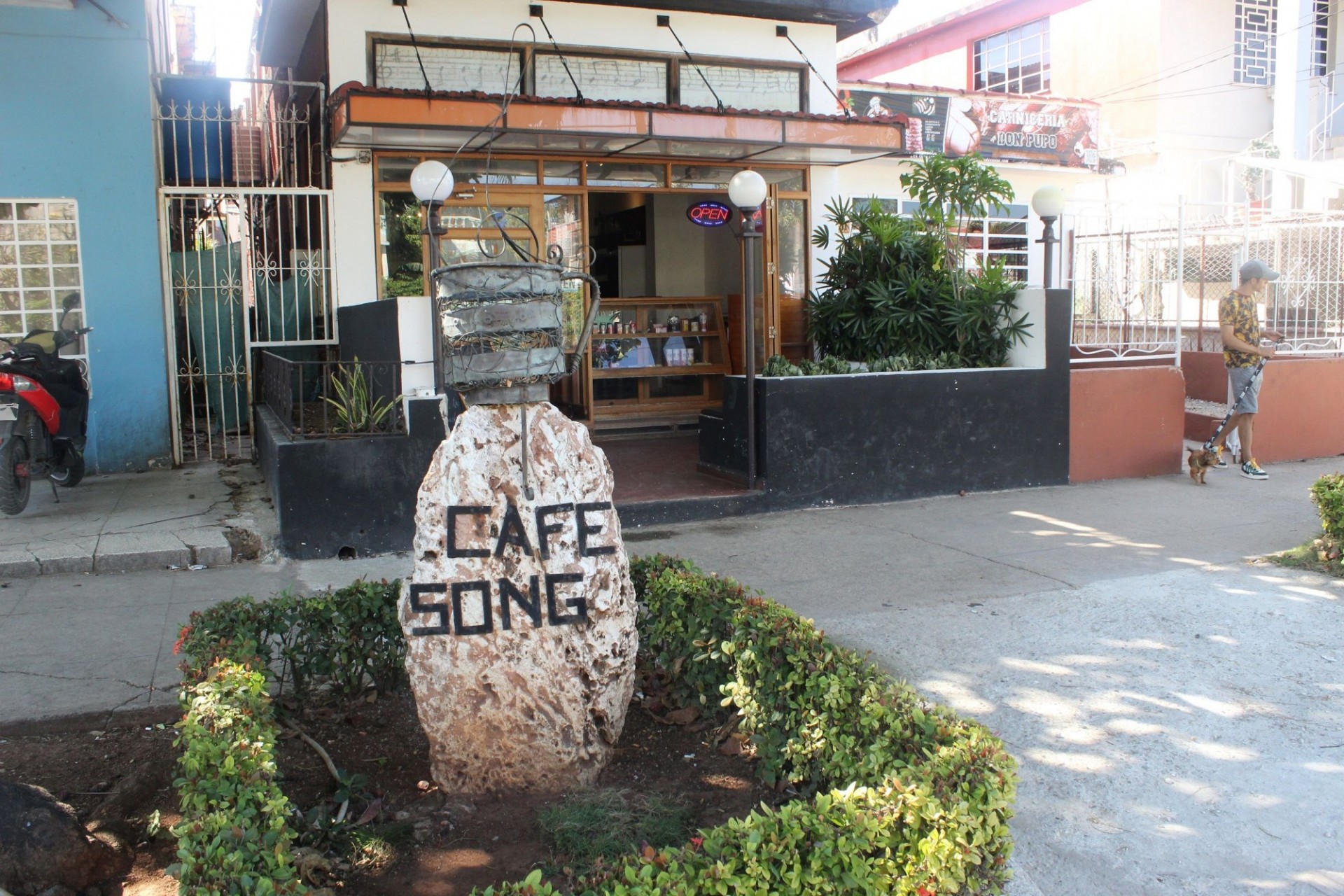 Pink granite stone announcing the restaurant behind behind “Cafe Song”.