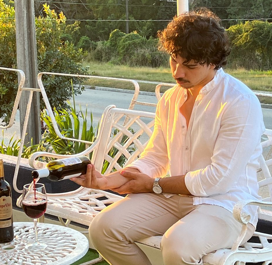 Hombre de camisa blanca sirviendo una copa de vino