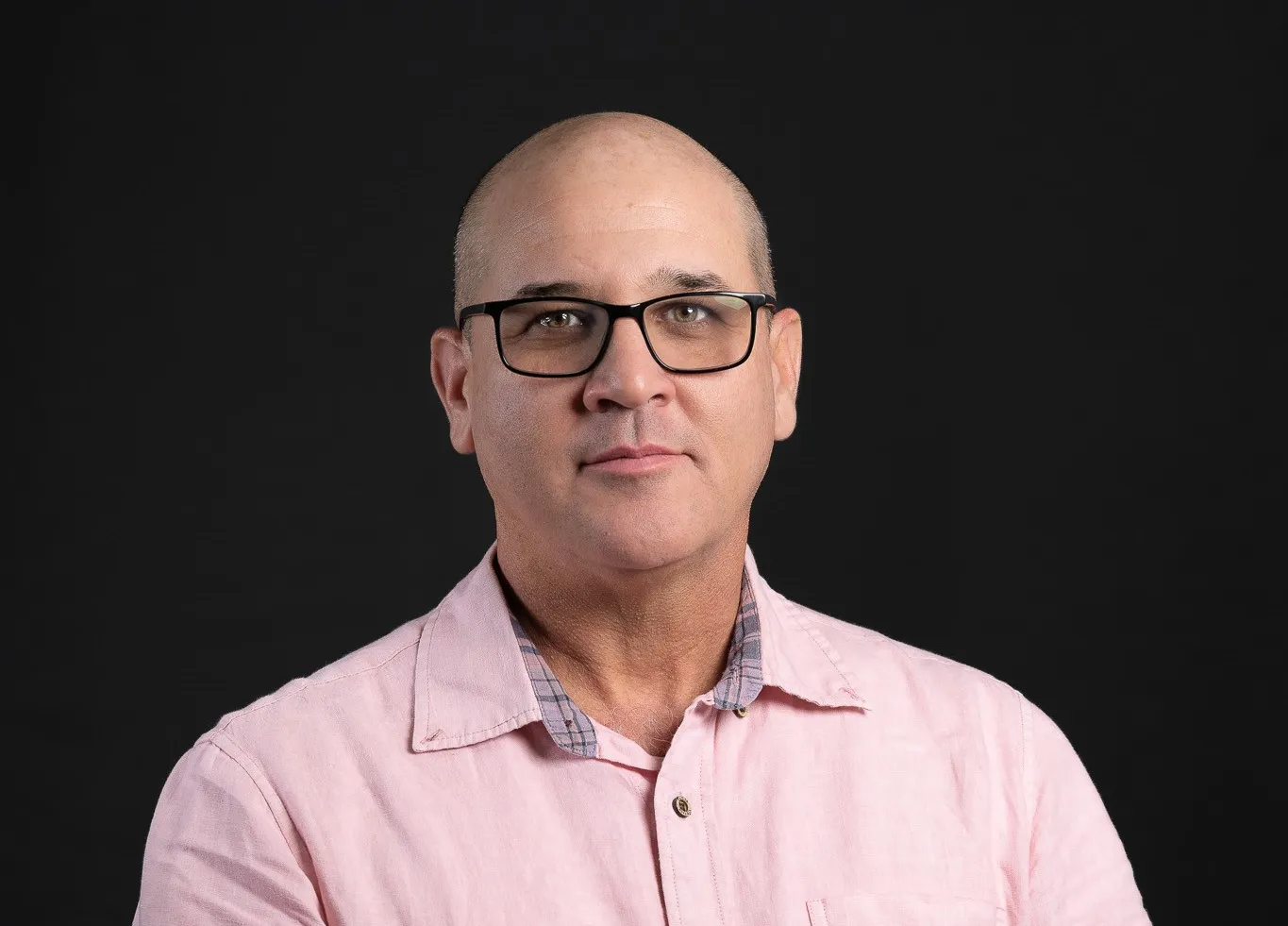 Man wearing glasses and a pink shirt