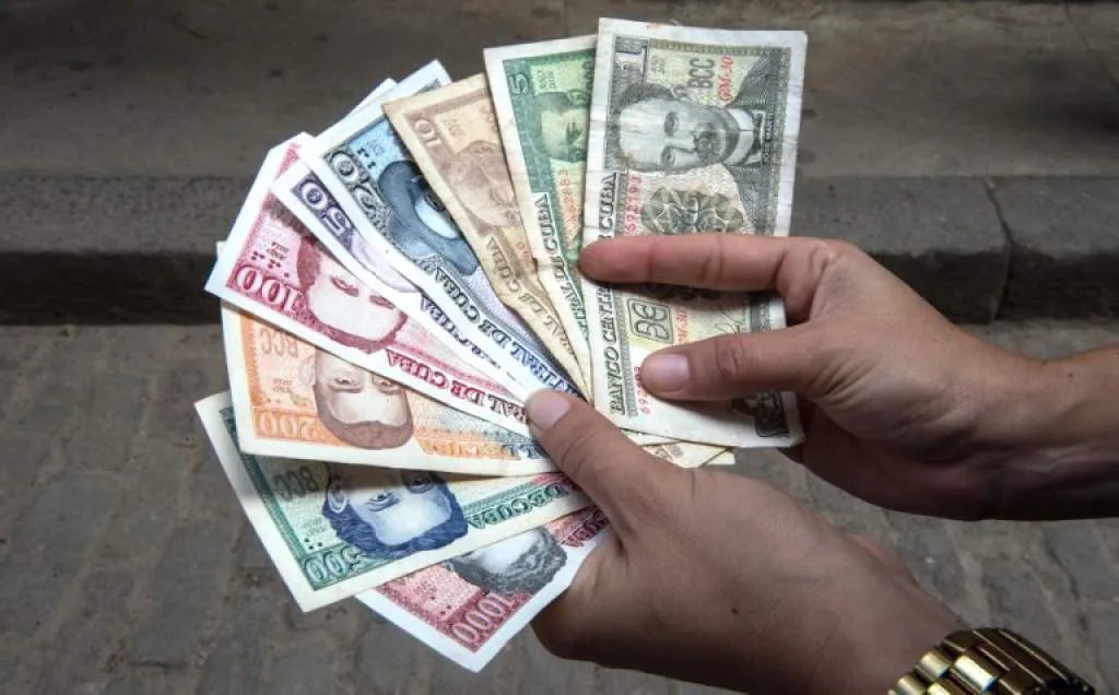 Two hand holding new Cuban bills open in the form of a fan