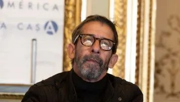 hombre portando gafas y mirando hacia arriba con camisa negra