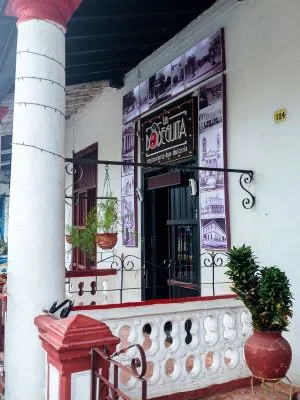 entrada de un restaurante pintada de blanco y rosado