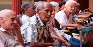 ancianos cubanos sentados en una fila 