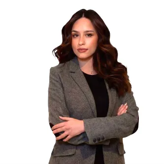 Woman with long dark hair looking at the camera with her arms crossed