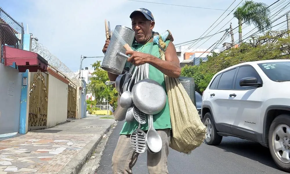 vendedor callejero con camisa verde cerca de un auto nuevo blanco