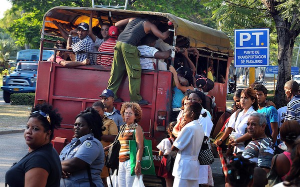 A red truck turned into transport vehicle with people boarding it